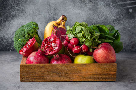 Fresh fruit and vegetables in wooden trayの写真素材