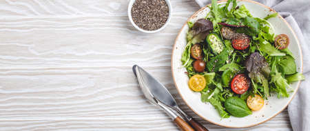 Vegetables vegetarian healthy salad with red yellow cherry tomatoes, green leafs and chia seeds