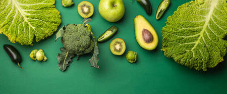 Creative layout food concept made of green fruit and vegetables on green backgroundの写真素材