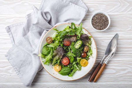 Vegetables vegetarian healthy salad with red yellow cherry tomatoes, green leafs and chia seedsの写真素材