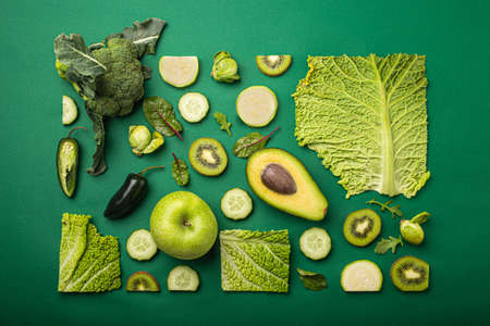 Creative layout food concept made of green fruit and vegetables on green backgroundの写真素材