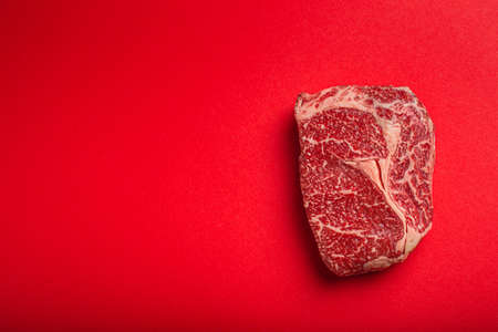 Raw meat beef prime cut steak Ribeye on clean red background from above, beefsteak concept banner minimalismの写真素材