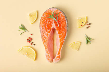 Raw fresh fish salmon steak top view on beige pastel background from above
