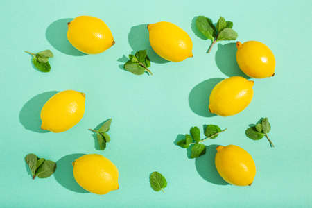 Lemons with mint on minimal blue background sun light hard shadows pattern backgroundの写真素材