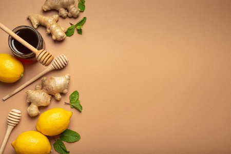 Orange detox drink, lemons, mint, ginger, honey in glass jar, honey wooden dippers top view. Food...