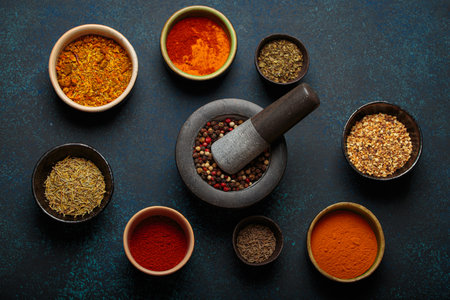 Mortar and pestle surrounded by colorful spices on dark backgroundの写真素材