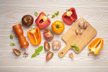 Fresh vegetables and spices lying on white wooden tabletop, healthy cooking concept top view