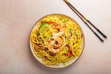 Pad thai noodles with shrimps, peanuts and lime on a plate, traditional dish of Thailandの写真素材