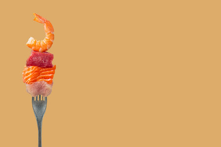 Diverse protein sources on a fork, pieces of raw salmon, beef, chicken and shrimp on orange yellow background, space for textの写真素材