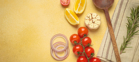 Cooking ingredients, fresh vegetables and wooden spoon on yellow background with copy space, cooking...