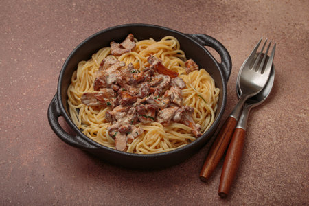 Creamy chanterelle mushroom pasta in cast iron pan with fork and spoonの写真素材