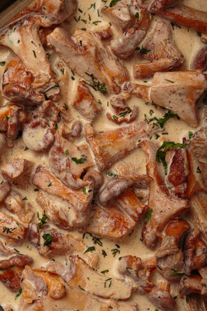 Chanterelle mushrooms frying in creamy sauce with dill and parsley close up top viewの写真素材