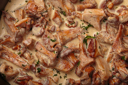 Chanterelle mushrooms frying in creamy sauce with dill and parsley close up top viewの写真素材