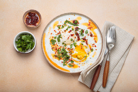 Turkish eggs cilbir, Middle Eastern style breakfast on beige background table top viewの写真素材