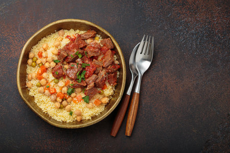 Moroccan couscous with tender meat and chickpea stew in rustic bow top view, Maghreb cuisine, space for textの写真素材