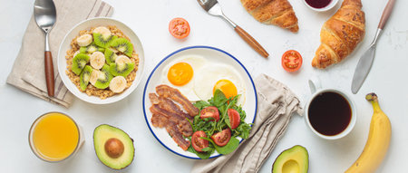Breakfast white table fried eggs vegetables salad, oats fruit, croissants, coffee, juice healthy...