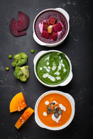 Three bowls with colourful vegetable soups black background healthy diet cooking detoxの写真素材