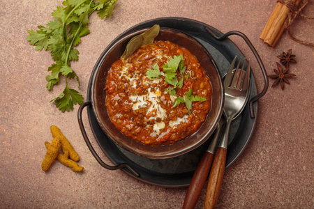 Dal makhani with cream and coriander in bowl is served with spices top view, traditional dish of...
