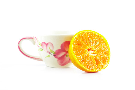 ripe orange with tea cup on white backgroundの写真素材
