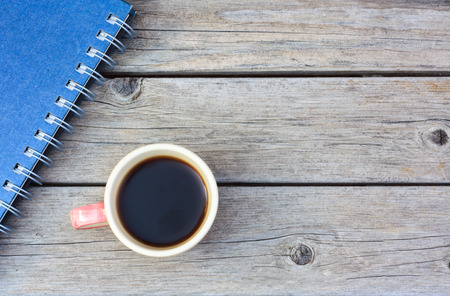 cup of coffee on wood background with bookの写真素材
