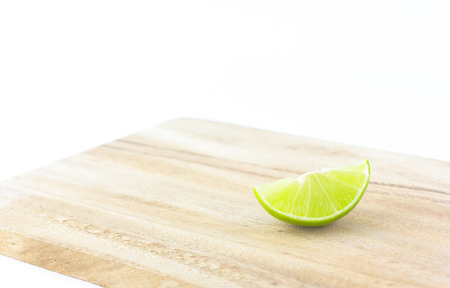 limes on chopping block on white backgroundの写真素材
