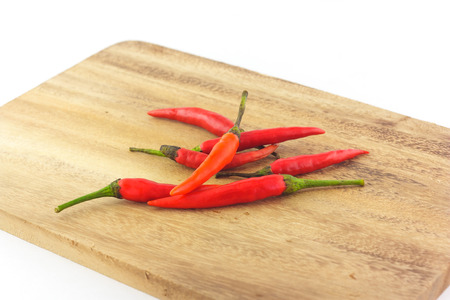 group of red chili on chopping block in white backgroundの写真素材