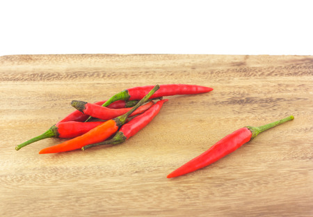 group of red chili on chopping block in white backgroundの写真素材