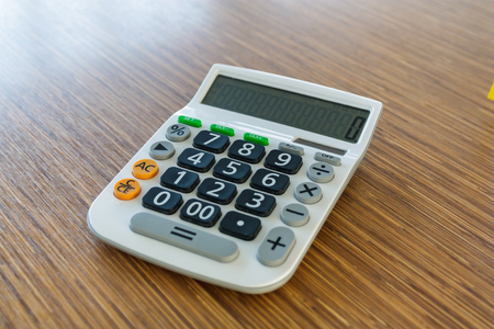 calculator on brown wood tableの写真素材
