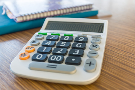 calculator on brown wood tableの写真素材