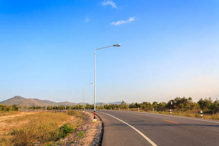 road on country side with clouds and blue skyの写真素材