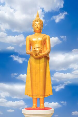 standing buddha image in the temple with clouds and blue skyの写真素材
