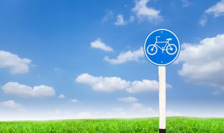 road sign on green grass and blue skyの写真素材