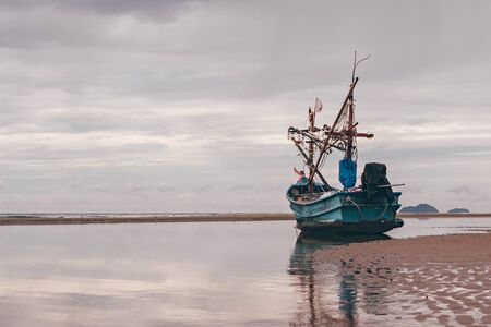 fishing boat waiting on the beach for high tide : Hua Hin  Thailandの写真素材