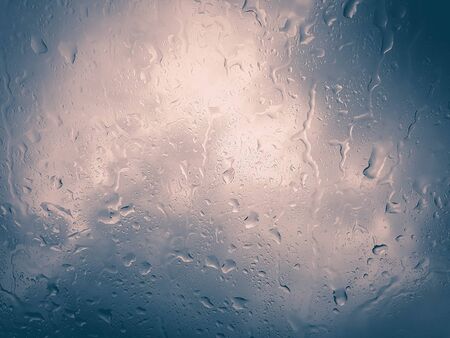 rain droplet on car window on white and blue backgroundの写真素材