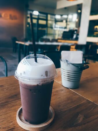 iced chocolate with cream and straw on wood table in cafe' shopの写真素材