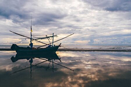 fishing boat waiting on the beach for high tide : Hua Hin  Thailandの写真素材