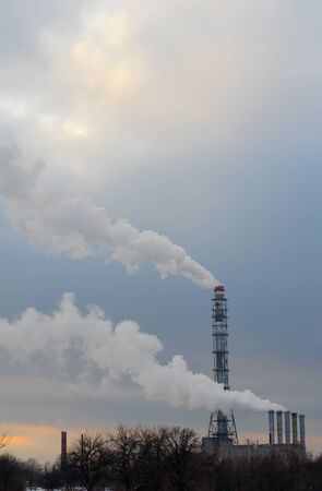 Smoking chimneys boiler on the background of winter treesのeditorial素材