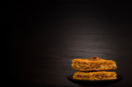 Baklava with honey on a black background, traditional Turkish sweets. Copy spaceの写真素材