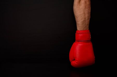 Two hands in red boxing gloves in the side of the frame on a black background,  empty spaceの写真素材