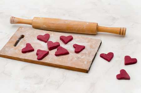 Wooden board with red hearts made of dough. Valentine's dayの写真素材