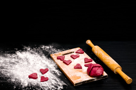 Red heart cookies on a black table, baking for Valentine's Dayの写真素材