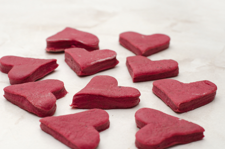 Red heart-shaped cookies on a white table closeup, baking for Valentine's Dayの写真素材