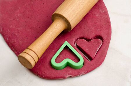 Sheet red dough with a rolling pin and cookie cutters heart, preparing for Valentine's Dayの写真素材
