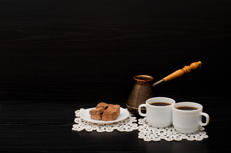 Side view of two cups of coffee on the lace napkins, chocolate dessert and Turkish potsの写真素材