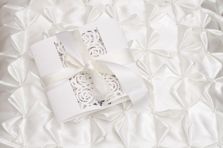 Openwork wedding invitation on a white satin backgroundの写真素材