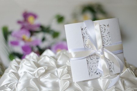 White wedding invitation on a satin pillowの写真素材