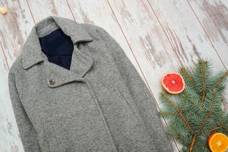 Fashion concept, gray wool coat, spruce branch and citrus