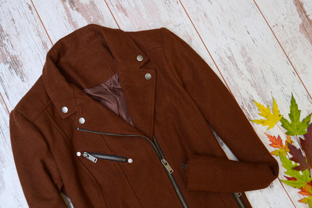 Brown cashmere coat autumn wooden background, autumn leaves. Fashion concept.の写真素材