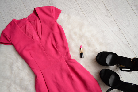 Fashion concept. Bright pink dress, lipstick and black shoes with white fur. top viewの写真素材