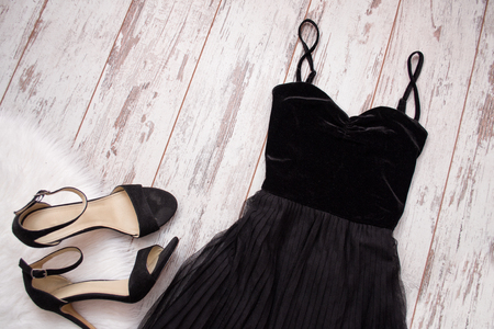 Black evening dress and shoes on a wooden background. Fashion concept. Top view, space for textの写真素材